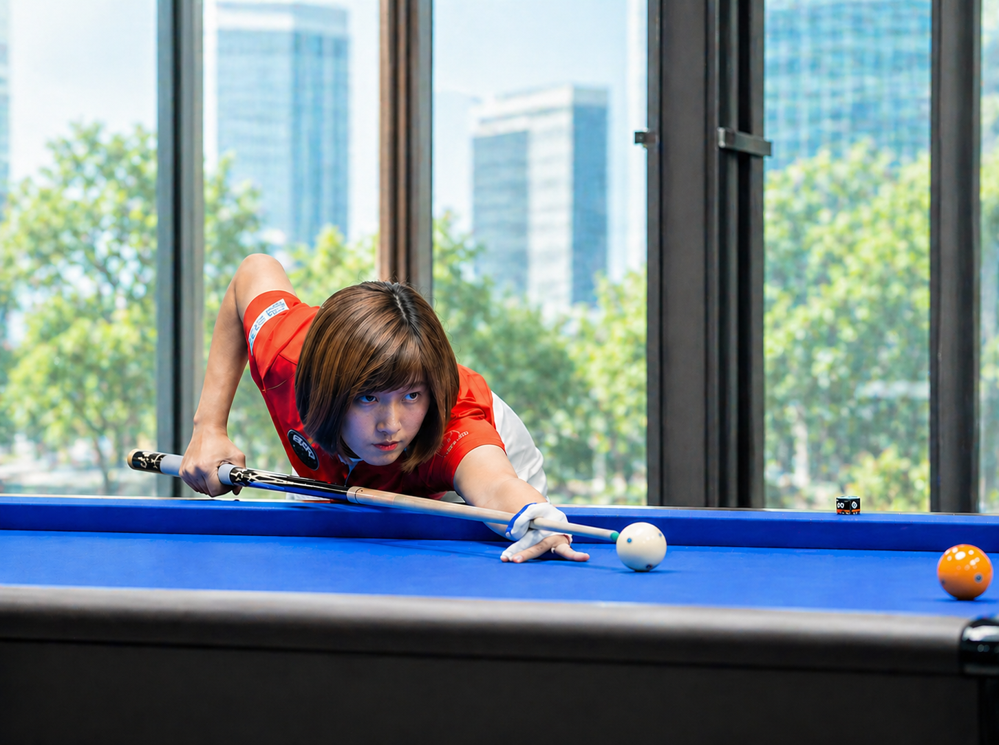 Vận động viên billiards vào thế đánh trên bàn carom